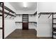 A walk-in closet with dark wood shelving, drawers, and wood-look tile flooring at 17802 Eastbrook Ter, Lakewood Ranch, FL 34202