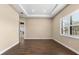 Spacious empty room with wood floors, a tray ceiling, and bright natural light at 17802 Eastbrook Ter, Lakewood Ranch, FL 34202