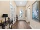 Inviting foyer with wood-look tile flooring, decorative lighting and glass accents, adjacent to French doors at 17802 Eastbrook Ter, Lakewood Ranch, FL 34202