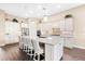Bright kitchen features stainless appliances, a large center island with seating and pendant lights, and hardwood floors at 17802 Eastbrook Ter, Lakewood Ranch, FL 34202