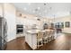 Open concept kitchen with stainless appliances, central island with seating, pendant lights, and hardwood floors at 17802 Eastbrook Ter, Lakewood Ranch, FL 34202