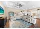 Open-concept living room featuring a large sectional, ceiling fan, and view of the kitchen at 17802 Eastbrook Ter, Lakewood Ranch, FL 34202