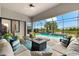 Relaxing screened patio with a pool view, comfortable seating, and a cozy fire pit at 17802 Eastbrook Ter, Lakewood Ranch, FL 34202