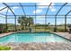 Gorgeous in-ground pool featuring a screen enclosure and waterfall feature at 17802 Eastbrook Ter, Lakewood Ranch, FL 34202
