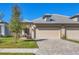 Charming home exterior featuring a beautiful paver driveway and lush green lawn at 17890 Cherished Loop, Bradenton, FL 34211