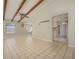 Open living room with tile flooring, exposed beams, ceiling fan, and view of kitchen at 4434 Meadow Creek Cir, Sarasota, FL 34233