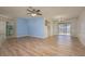 Open-concept living and dining area with wood-look floors, blue accent wall, and sliding glass doors at 4434 Meadow Creek Cir, Sarasota, FL 34233