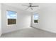 Well-lit bedroom with gray carpet, ceiling fan and two windows at 4704 Foxtail Dr, Parrish, FL 34219