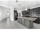Modern kitchen with granite island, gray cabinets, and tile floors at 4704 Foxtail Dr, Parrish, FL 34219