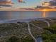 Sunset over serene beach with tranquil water; showcasing a perfect spot for relaxation at 5919 Gulf Of Mexico Dr, Longboat Key, FL 34228