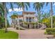 Two-story home with circular driveway, balconies and palm trees at 5919 Gulf Of Mexico Dr, Longboat Key, FL 34228