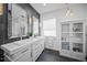 Elegant bathroom with double sinks, decorative mirrors, pendant lights, and stylish storage, blending form and function at 7139 Sandhills Pl, Lakewood Ranch, FL 34202