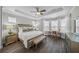 Luxurious main bedroom with hardwood floors, tray ceiling, and a cozy sitting area at 7139 Sandhills Pl, Lakewood Ranch, FL 34202