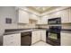 White kitchen cabinets, black appliances and granite countertops at 766 N Jefferson Ave # 766, Sarasota, FL 34237