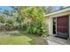 Front exterior of home with mature landscaping and a red front door at 766 N Jefferson Ave # 766, Sarasota, FL 34237