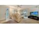 Living room with beige recliner sofas and sliding glass doors to screened patio at 766 N Jefferson Ave # 766, Sarasota, FL 34237