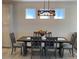 Dining room with a dark wood table, gray chairs, and a modern light fixture at 1045 Crosswind Ave, Sarasota, FL 34240