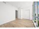 Bright bedroom featuring wood floors, white walls, closet, and window with city views at 111 Golden Gate Pt # 602, Sarasota, FL 34236