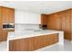 Modern kitchen boasts sleek, wood and white cabinetry, stainless appliances, and a large center island at 111 Golden Gate Pt # 602, Sarasota, FL 34236