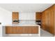 Modern kitchen featuring a large island, wood cabinets, and stainless steel appliances at 111 Golden Gate Pt # 602, Sarasota, FL 34236