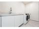 Clean laundry room featuring sleek white cabinetry, modern washer, and dryer at 111 Golden Gate Pt # 602, Sarasota, FL 34236