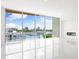 Bright, empty living room with white tile floors, a modern fireplace, and scenic harbor views at 111 Golden Gate Pt # 602, Sarasota, FL 34236