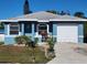 Blue house with a white garage door and landscaping at 1308 72Nd E St, Palmetto, FL 34221