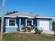 Blue house with a white garage door and landscaping at 1308 72Nd E St, Palmetto, FL 34221