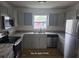 Bright kitchen with stainless steel appliances, gray cabinets, granite countertops, and window above the sink at 1308 72Nd E St, Palmetto, FL 34221