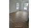 A bright living room features newly installed hardwood floors and freshly painted walls with large, light-filled windows at 1308 72Nd E St, Palmetto, FL 34221