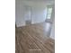 An open-concept living space with new wood flooring, freshly painted walls, and natural light from a large window at 1308 72Nd E St, Palmetto, FL 34221