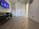 Spacious room featuring wood-style flooring and a media console with a door and closet at 15618 Castle Park Ter, Lakewood Ranch, FL 34202