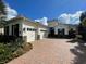 Charming home with a three-car garage, stone accents, and a brick driveway at 15618 Castle Park Ter, Lakewood Ranch, FL 34202