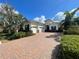 Beautiful single-Gathering home with a three-car garage, brick driveway, and manicured landscaping at 15618 Castle Park Ter, Lakewood Ranch, FL 34202