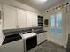 Laundry room with modern appliances, ample counter space, and sleek white cabinetry at 15618 Castle Park Ter, Lakewood Ranch, FL 34202