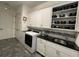 Laundry room with front load washer and dryer and a black granite counter top with a stainless steel sink at 15618 Castle Park Ter, Lakewood Ranch, FL 34202