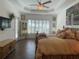 Spacious bedroom featuring wood floors, a ceiling fan, a large window, and unique decor at 15618 Castle Park Ter, Lakewood Ranch, FL 34202