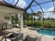 Inviting screened patio featuring an outdoor kitchen, pool, hot tub, and golf course views at 15618 Castle Park Ter, Lakewood Ranch, FL 34202
