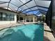 A large pool with screened enclosure, lounge chairs, and covered outdoor kitchen at 15618 Castle Park Ter, Lakewood Ranch, FL 34202
