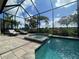 Inviting screened-in pool with a spa and a scenic golf course view beyond at 15618 Castle Park Ter, Lakewood Ranch, FL 34202
