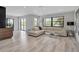 Bright living room with a white sofa, wood floors, and backyard pool views at 1649 Stanford Ln, Sarasota, FL 34231