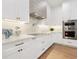 Modern white kitchen with high-end appliances and custom cabinetry at 1827 Morris St, Sarasota, FL 34239