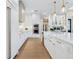 White kitchen with island, stainless steel appliances, and light wood floors at 1827 Morris St, Sarasota, FL 34239