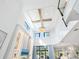 High-ceiling living room with chandelier, stone wall, and TV at 1827 Morris St, Sarasota, FL 34239