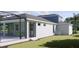 Exterior of house featuring lush green grass, screened lanai, white stucco and dark window trim at 217 S Shade Ave, Sarasota, FL 34237