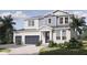 Charming two-story home with a well-manicured lawn, a three-car garage, and a covered entryway at 217 S Shade Ave, Sarasota, FL 34237