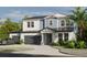 Two-story home with a three-car garage, lush landscaping, and an elegant covered entryway at 217 S Shade Ave, Sarasota, FL 34237