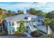 Aerial view of a two-story light green building with a metal roof, surrounded by lush tropical landscaping at 294 Hidden Bay Dr # 203, Osprey, FL 34229