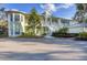 Eye-level view of a light green two-story building with a metal roof and lush landscaping at 294 Hidden Bay Dr # 203, Osprey, FL 34229