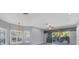 Spacious living room with wood-look floors, plantation shutters, and balcony access at 294 Hidden Bay Dr # 203, Osprey, FL 34229